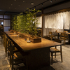 と - メイン写真:竹林のオブジェがあるテーブルタイプのカウンター席とメインダイニング
