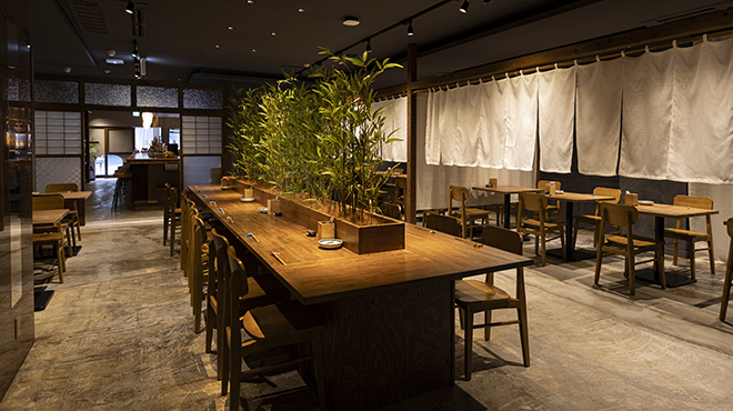 と - メイン写真:竹林のオブジェがあるテーブルタイプのカウンター席とメインダイニング