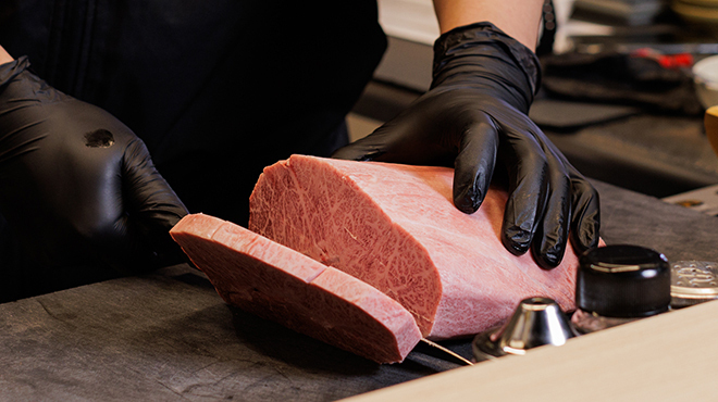 焼肉 日の出 - メイン写真:肉をカットしているところ（記載なし）