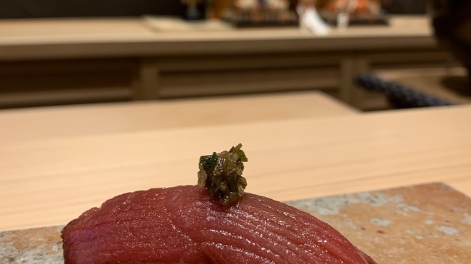 鮨かしわ - 料理写真:鮪のノビル醤油漬け
      栽培野菜や八百屋が無かった時代
      薬味は野草でした
      鮮度を保つ為
      塩漬けや醤油漬けの食材を
      美味しく食べる為の知恵は
      野草の使い方だったと思い
      旨味と香りたっぷりの
      ノビルを使い
      アクセントにしました
      鮪と醤油の相性は抜群
      江戸庶民が
      愛した慣れ親しんだ味
      それを考察するのが
      楽しい逸品です
