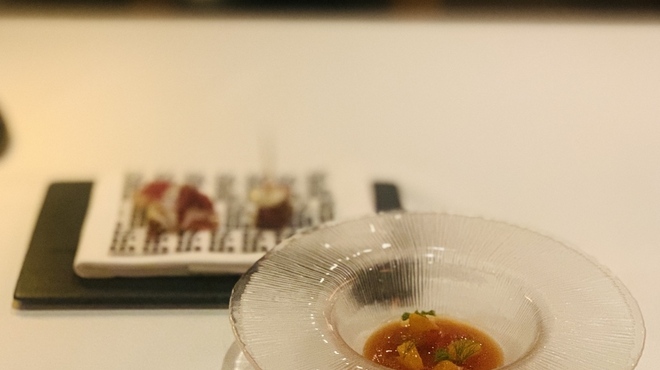 IZURUN - 料理写真:⑤【トマトです】
              ★ 蜜柑入りトマトのサルモレホ（冷製スープ）、レモン皮+丁子（クローブ）の香り付け、ピンチョス2種（イベリコ豚肩ロースのサラミ+水牛モッツァレラ、放牧バスク豚生ハムのブルスケッタ）