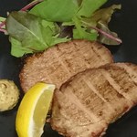 Grilled smoked pork shoulder loin with mustard and lemon