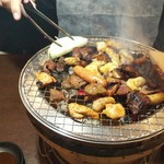 福山駅前酒場　情熱ホルモン - 友人が焼き上がり具合確認中(2019.02.05)