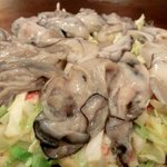 おうさか苑 - 「カキ玉」（焼いている途中）：お好み焼きからこぼれんばかりの牡蠣♪ 
