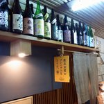 Uoshou Kaji - お店の外観です。 入口の上部には、沢山の酒瓶が飾ってありました。