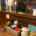 東京とんこつ とんとら - テーブル調味料。左端に生にんにく。上に、にんにく絞り器？あり。陶器は紅生姜と辛味噌でした。