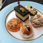 The Drawing Room - 奥の黒いパンは卵サンド、左はピリ辛ソースのスパイシーチキン、右はクリームチーズを包んだスモークサーモン