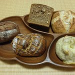 しぜんこうぼのぱんや きなり - 中央下から時計回りに：めでたいぱん、大人のチョコぱん、ライ麦75％くるみぱん、きなりぱん、こんぶチーズぱん