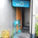 楽観 - 入口の前まで来ないと見えないサインと暖簾