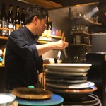 炭焼 おかげさん - 焼き台を横目に格闘する店主