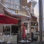 TOSCANA CAFE & WINE BAR - 店舗外観。店舗周りをガラスで囲われたテラス席がさらに囲っています。