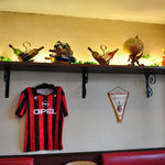 トラットリア ラ スクーデリア - 壁にはミランのユニフォームとペナント