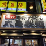 丸亀製麺 - 2019/05 渋谷の道玄坂の左側を上がって行った途中の雑居ビルの１階に位置する 丸亀製麺 渋谷道玄坂店。手前の隣はその雑居ビルの地下１階にある HUB 渋谷道玄坂店の入口だ