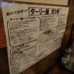 インド定食ターリー屋 - お店に入るとターリー屋虎の巻と書かれた看板が席の横に備えられており
      高いイメージのあるインド料理を、手軽に財布にやさしく楽しめるお店である事が書かれています。