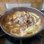 さとり - 「牛カルビ（辛口）煮込みうどん」煮込み終えたところ。牛カルビが大量に載っているので、食し足りないと言うことはなかろう。長ネギもまた肉に相応した量がふんだんに投入されている。ともに充分に満足出来る量だ。