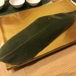 梅丘寿司の美登利 - このシャリ半分カットは、実はなかなかの離れ業なのだ。この一貫一貫の寿司でカットしたシャリをどこに持って行くかが問題なのだ。（笑）そのまま残しておくと、如何にも食べ散らかした感があって、周りの人にも不快であろう。光り物では、ネギも多用するので、ネギも残してシャリも半分残しておいたら、通常だと「汚い皿」が残る。ここが和食の素晴らしいところで、「敷き葉」がある。この下に隠すのだ。（笑）