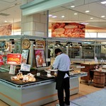 パン工場 - 外観。店員がまとめ売りの袋詰め作業中