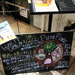 CRUST - ピザプレートの手書きの看板。