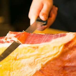 Freshly sliced Spanish Prosciutto served with wine.