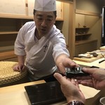 日本橋蛎殻町 すぎた - 杉田ご主人からの手渡された大きな焼きホタテ海苔巻き。手のひらいっぱいの大きさ。