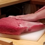 鮨 さかい - 本鮪の捌き
      この日は博多でG20開催。
      交通規制があり高速道路が封鎖され、一般車両の市内乗り入れ自粛という状況。
      運送便も大幅遅配し、本鮪の到着も遅れ、提供の合間に今日の本鮪を捌きます。