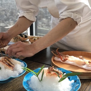 The chef prepares a whole crab in front of the customer.