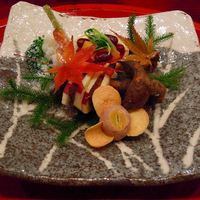草喰 なかひがし - 冬景色をしつらえた、右が雪、黒豆。クワイせんべいを山茶花に見立て、カツオ生節、リンゴと北山の鹿の燻製