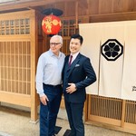 山地陽介 - 山地の師匠・アラン・デュカス氏と玄関ののれん前で。