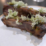 Kabi - 炭火焼のスペアリブ。人参の花、青唐辛子とカシスの葉っぱのピクルス、実山椒を乗せて。