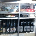 亀の家食堂 - ビールは瓶のみ！
      上の棚には今日のタコ刺が
      トマトの横には自家製焼豚が鎮座