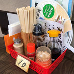 角屋食堂 - 卓上の調味料。うちわは常備。
