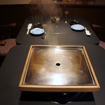 ステーキハウス 村岡 - 予約していたので、既に準備万端でセッティングされていましたよ。 奥の良い席を確保していてくれたようです。 嬉しいですよね。 手前に写っている、真ん中から蒸気が出ている装置が今日のメイン料理を仕上げてく