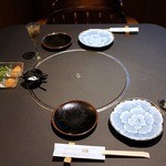 ステーキハウス 村岡 - では、席に座りましょうか。 おや、食前酒が既に用意されているようですね。 取り皿が綺麗ですよね。 特注で作った有田焼だそうです。 コース仕立てになっている料理に色々と使われていました。 こうゆう感じの