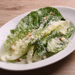 Caesar salad of romaine lettuce topped with freshly shaved cheese