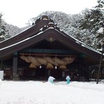 おくに - ポンチョを着て神楽殿の雪かきをする神主さま