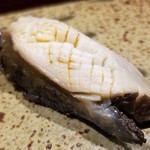 鮨匠 のむら - (26)炊き黒鮑(佐賀県唐津産)
      産卵期は秋～冬(禁漁)、旬は初夏～夏。
      6時間、大根の煮汁100%で炊き込んだ黒鮑は、大変柔らかく、その身がプルプルと震え、旨みも抜群です。