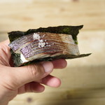 Bite of grilled mackerel wrapped in seaweed