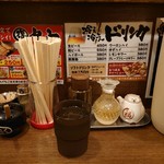 ラーメン うづまき - 卓上、ドリンク案内と調味料