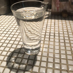 鳥伊勢 - タイル貼りのカウンター。グラスの中身は日本酒。