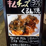 くるん - 店前の看板です。 キムチーズ３００円 くるん焼 写真付きですね。 これは、面白いですね。 店名と同じ商品名なんですね。 これを食べてみましょか。  店内でも食べれるようですしね。