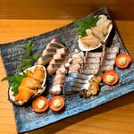 小魚料理 とみ助 - 写真左から赤貝、鰆のたたき、たこ、しめ鯖、サザエ、太刀魚の焼き霜造り、みる貝の豪華7点盛り合わせになります❣️(o^^o)