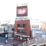 ぶっかけ亭本舗 ふるいち - 倉敷駅の南側、天満屋の前の歩道橋から見える看板。お店はこのビルの横の路地を50mほど行ったところにある