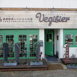 軽井沢ベジビエ - 軽井沢ベジビエの店頭、軽井沢らしいお洒落な文字とベジビエを彷彿とさせる緑ガラス窓・ドアとくすんだ白色の建物です。