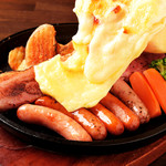 Bacon and sausage topped with raclette cheese