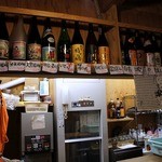 安来や - カウンター前には沢山のお酒が並んでいましたよ。 日本酒、焼酎、どちらも堪能できそうです。 そうそう、日本酒には力を入れているようです。