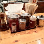 田中商店 - 卓上調味料　手前右からニンニク・ラーメンのタレ、すりごま、楊枝、その奥２列目右から高菜、紅ショウガ、胡椒