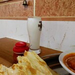 アソパラウ - サービスドリンクのラッシーです。左の小さな瓶は辛味調味料。ちょっと入れるだけで結構辛くなります。