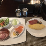 カスケイドカフェ - 朝食ビュッフェ４２８８円（総額）。第一弾。コールドミート、サラダ、スモークサーモン、メロン、チーズオムレツ、きのこのソテー、ベーコン。コロナ対策ラップ？ とても美味しくいただきました（╹◡╹）