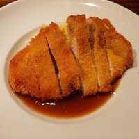 シャンパン食堂 - 豚ロースのカツレツに柚子胡椒の爽やかさと塩気がきいたソース、付け合わせはカレー風味の千切りキャベツ