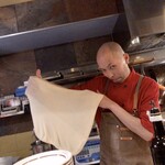 フォカッチャディレッコ500 - フォカッチャディレッコの生地を広げる岩井さん。